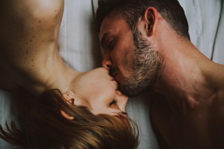 high angle view couple kissing while lying bed home 1048944 24917057