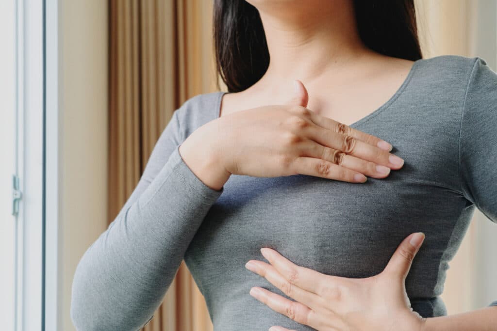 woman hand checking lumps her breast signs breast cancer 1024x683 1