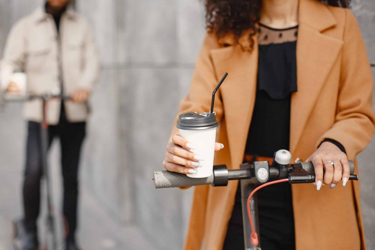 european girl anindian guy ride scooters smile people with coffee scaled