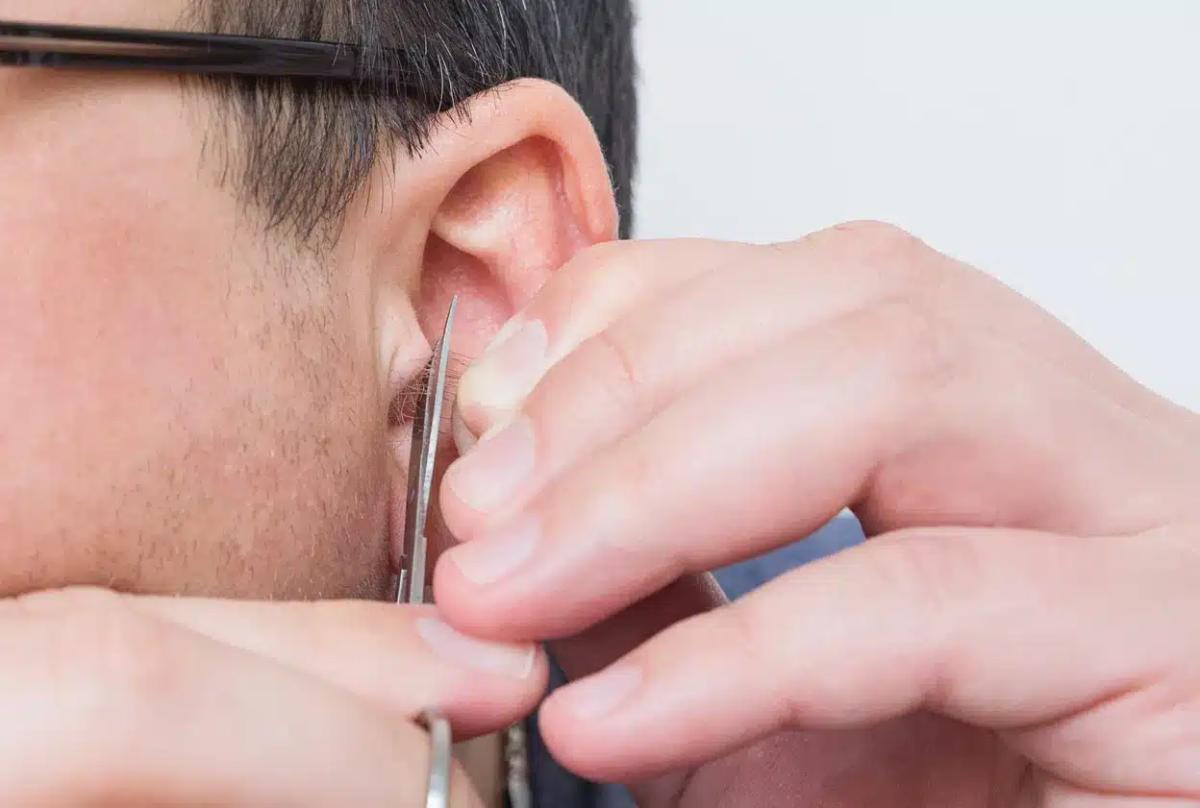 man trims ear hair