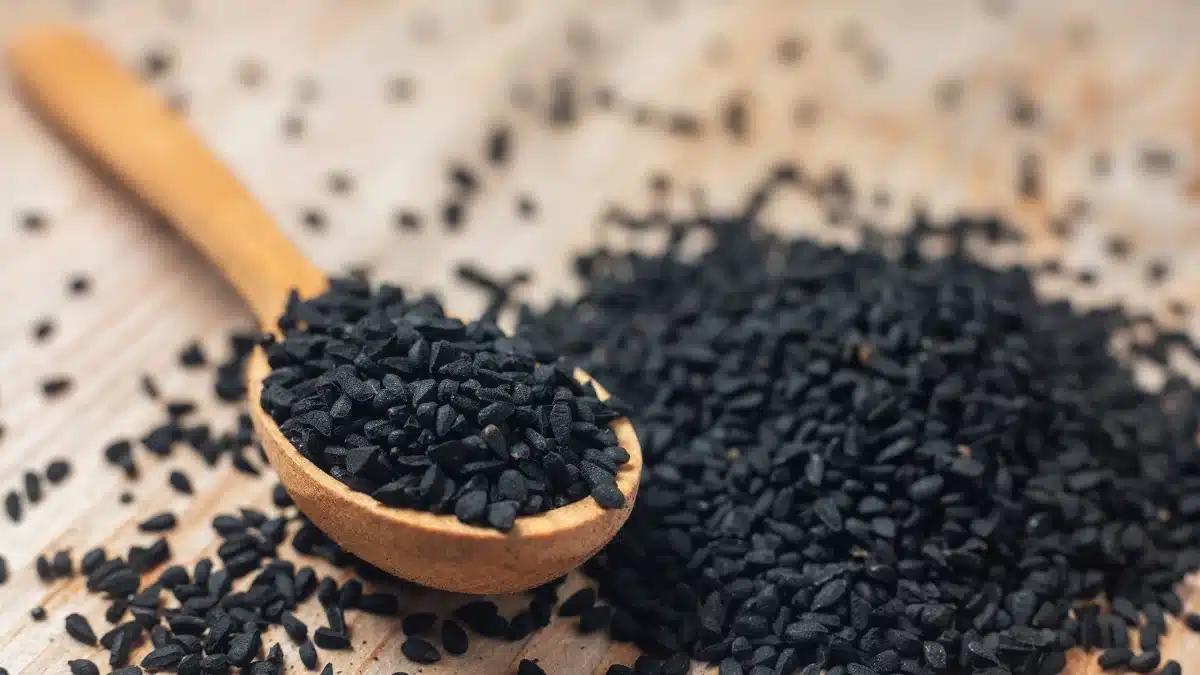 19c8f41e bigstock black cumin seeds on wooden sp 425676851