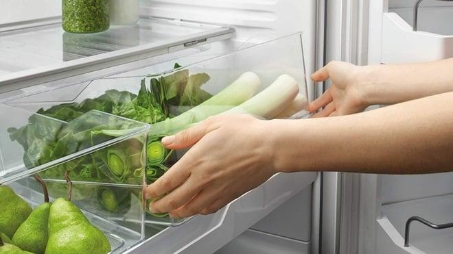 person taking vegetables out of fridge crisper