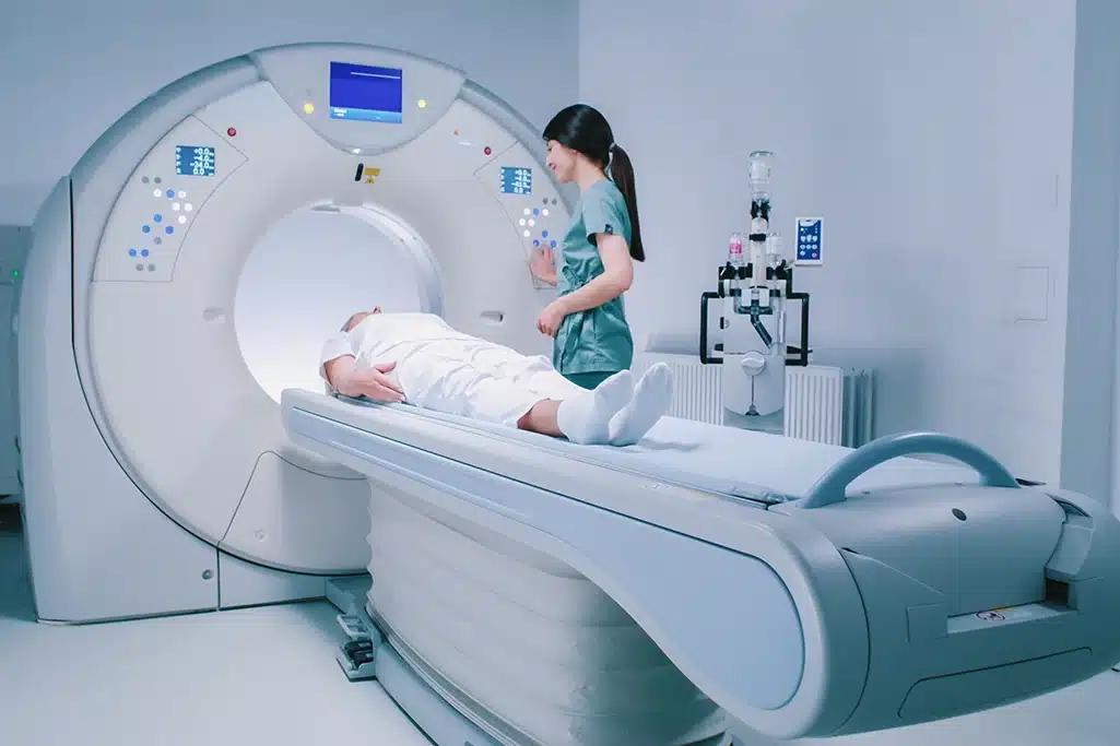 ct technologist smiling at patient as she starts ct scan