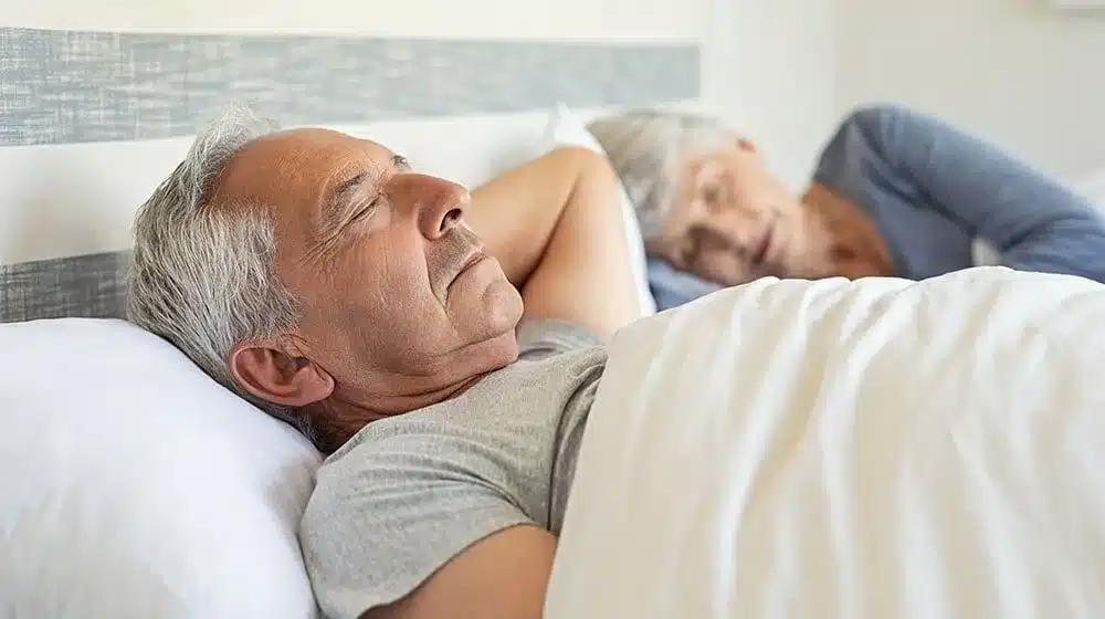 12oaks senior man and woman sleeping on bed ss best sleep positions for seniors feature